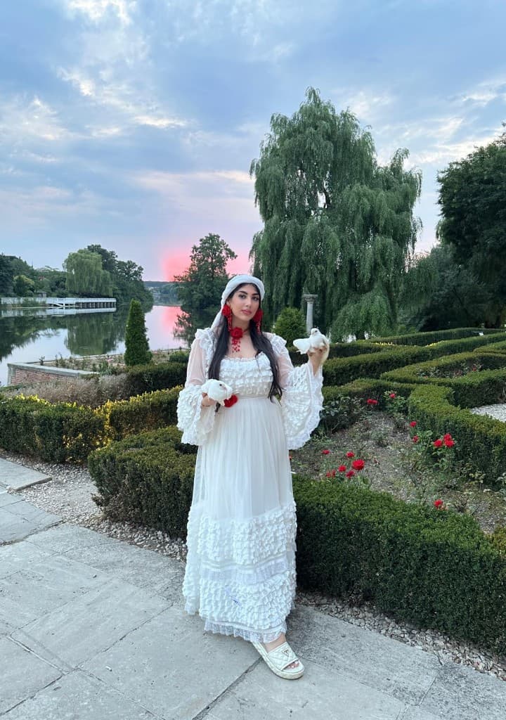 Cassiana în rochie albă, cu porumbei, în grădină